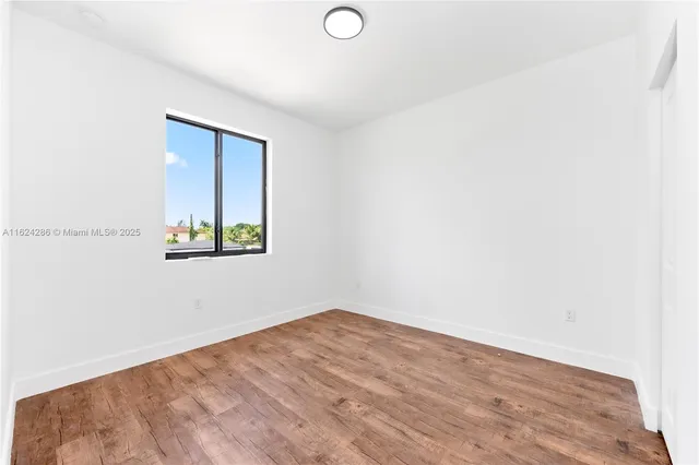 a view of a room with wooden floor and window