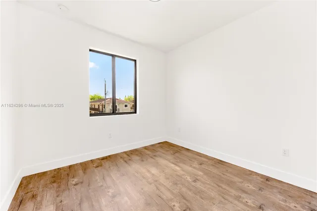 a view of empty room with wooden floor