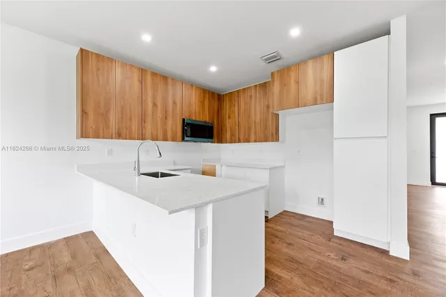 a kitchen with a sink a stove a refrigerator and a microwave