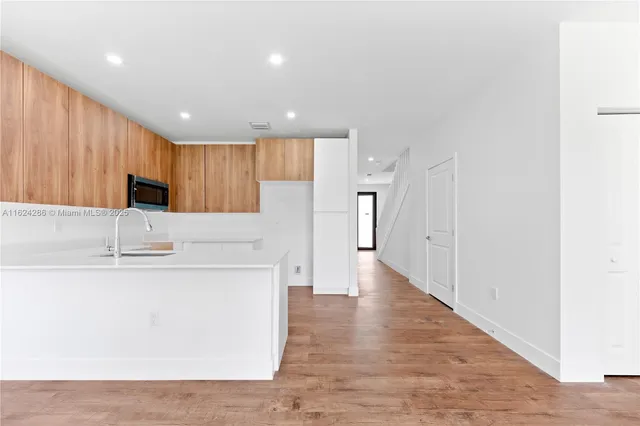 a kitchen with kitchen island a sink stainless steel appliances and cabinets