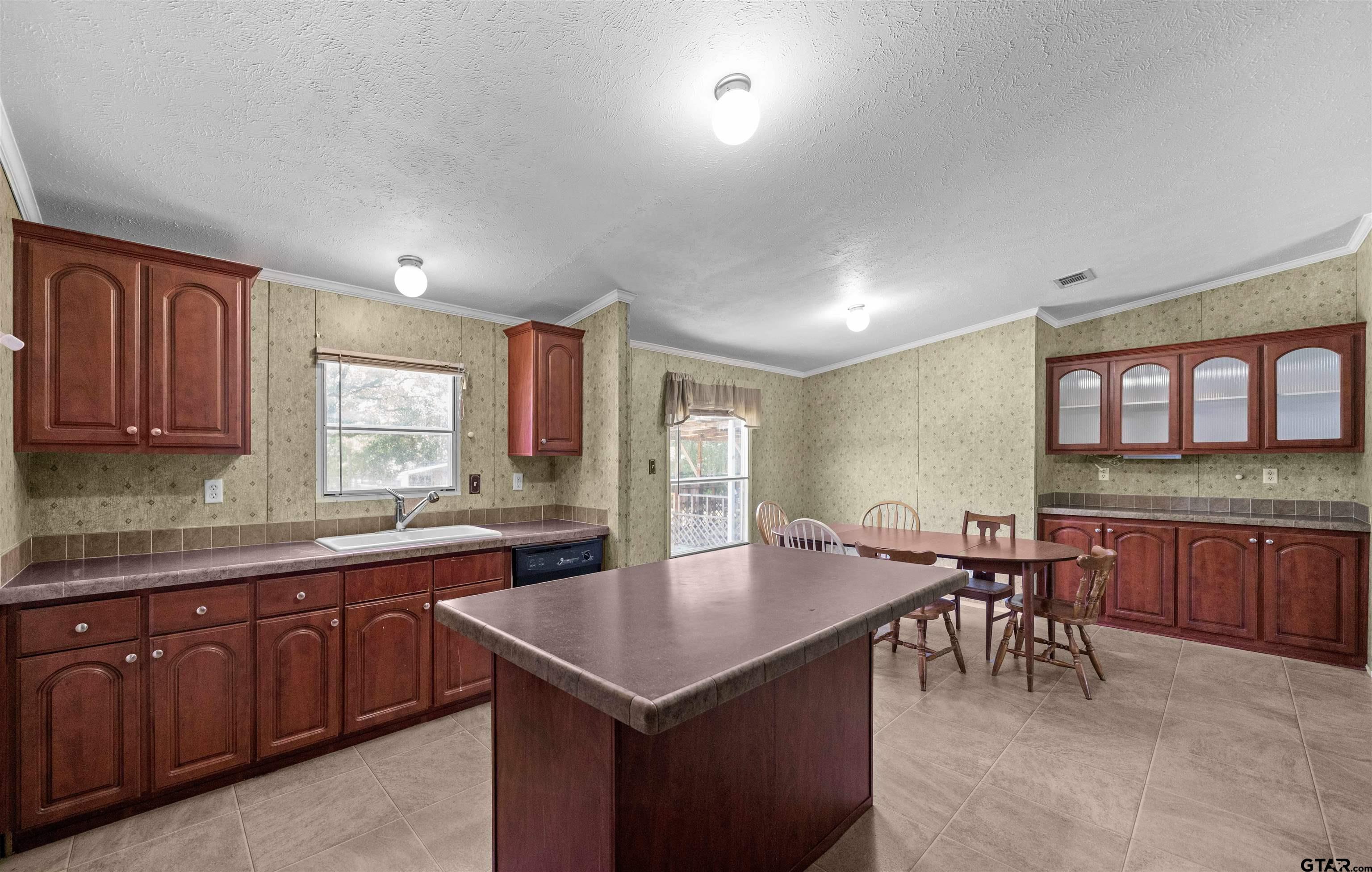 5611 Holiday Hills Road Tyler, TX 75708 - Photo 11 of 38 a kitchen with a stove a sink a dining table and chairs