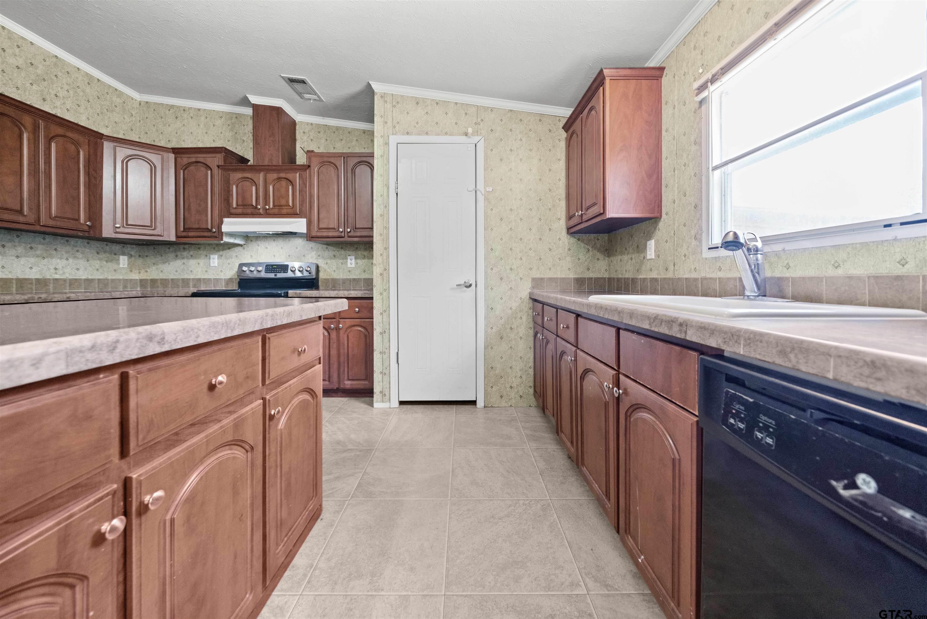 5611 Holiday Hills Road Tyler, TX 75708 - Photo 14 of 38 a kitchen with stainless steel appliances granite countertop a sink stove and cabinets
