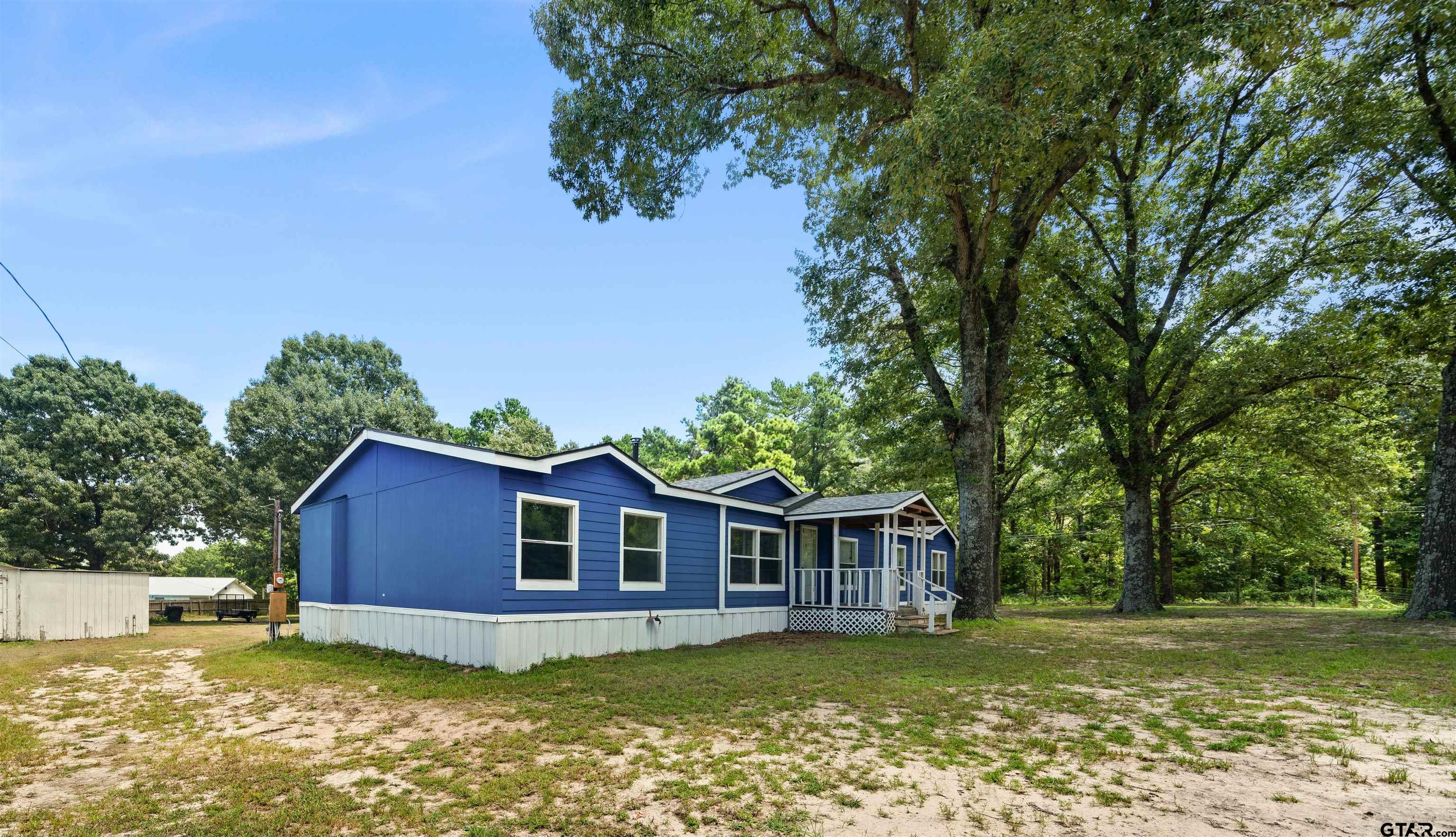 5611 Holiday Hills Road Tyler, TX 75708 - Photo 2 of 38 a view of a yard in front of a house with large trees