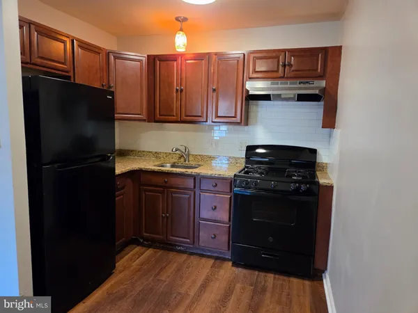 a kitchen with stainless steel appliances granite countertop a refrigerator and a stove