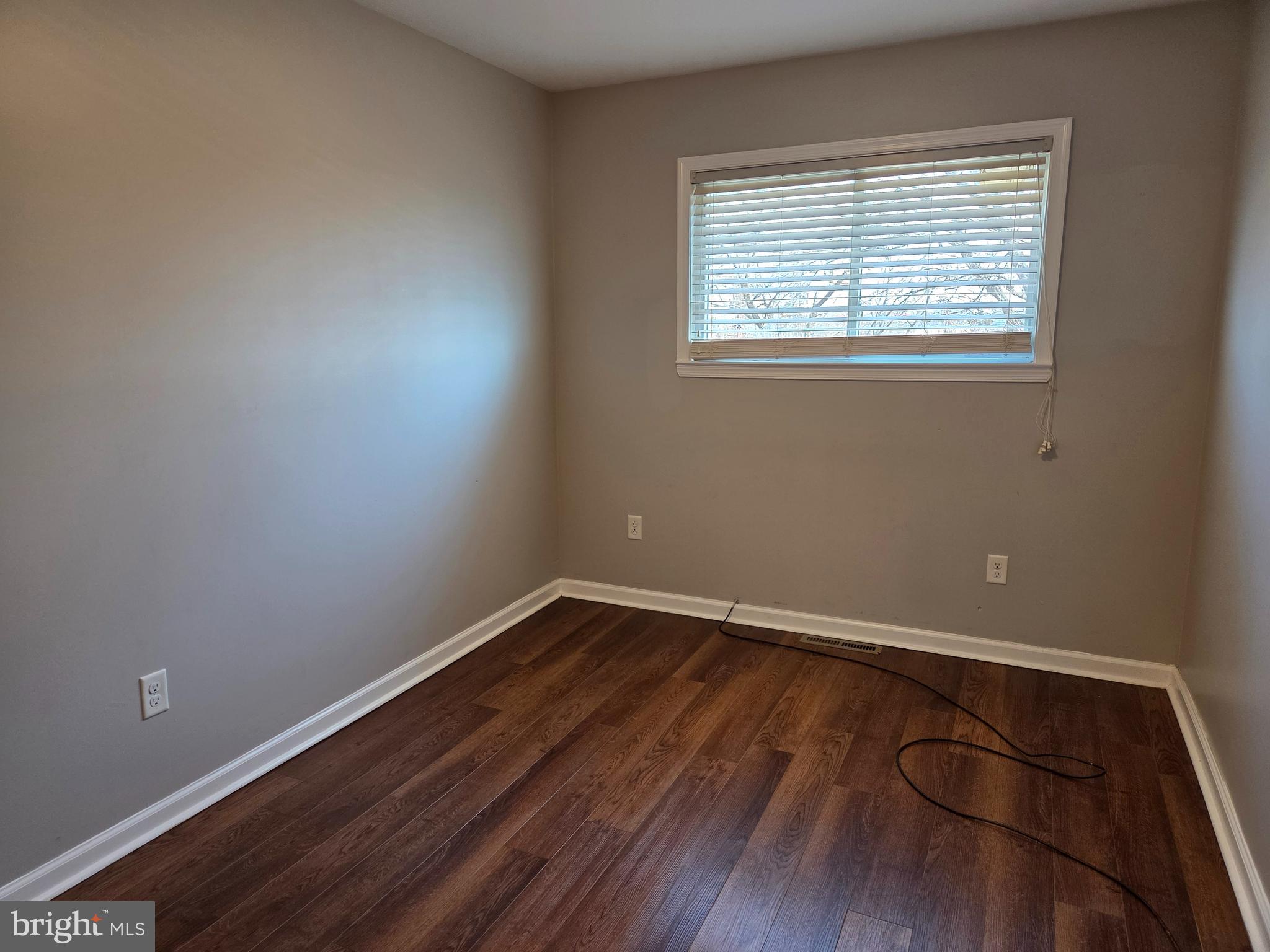 561 Homestead Road, Unit A Wilmington, DE 19805 - Photo 6 of 11 an empty room with wooden floor and windows