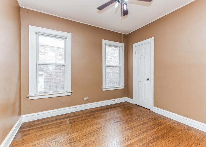 10805 South Normal Avenue Chicago, IL 60628 - Photo 14 of 26 a view of an empty room with a window and wooden floor