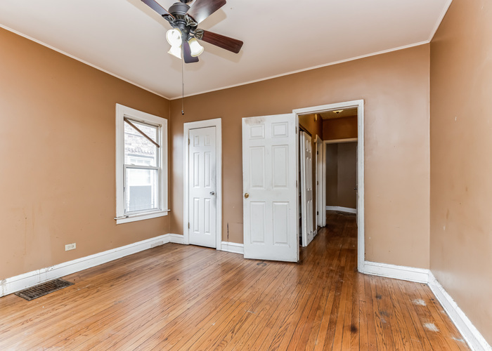 10805 South Normal Avenue Chicago, IL 60628 - Photo 17 of 26 a view of a livingroom with wooden floor and a ceiling fan