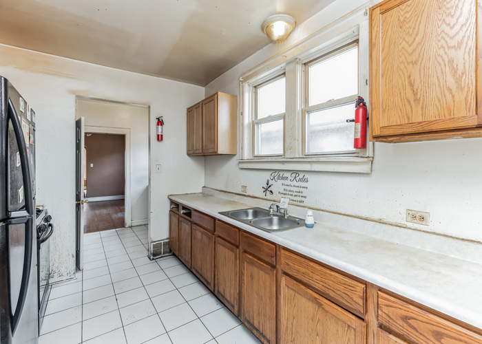 10805 South Normal Avenue Chicago, IL 60628 - Photo 22 of 26 a kitchen with a sink and cabinets
