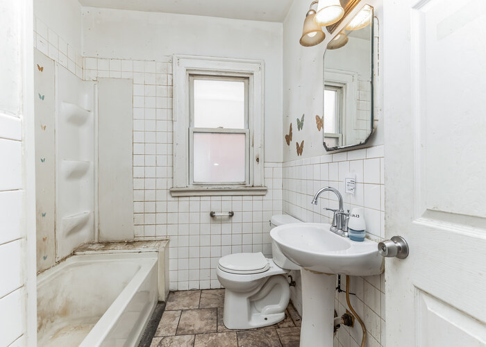 10805 South Normal Avenue Chicago, IL 60628 - Photo 25 of 26 a bathroom with a granite countertop sink a toilet and bathtub