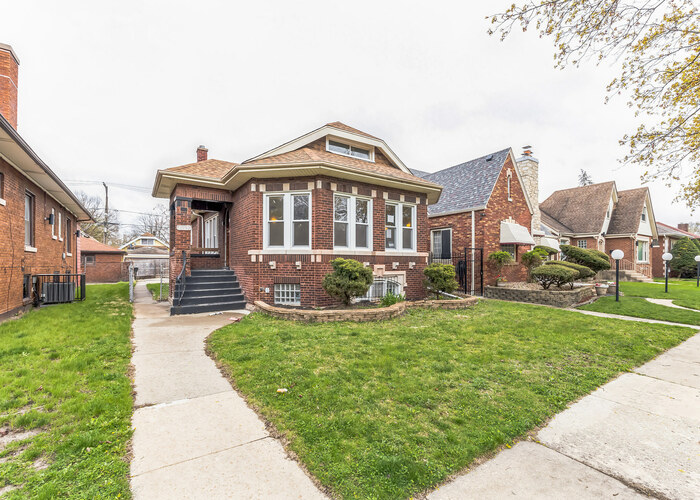 10805 South Normal Avenue Chicago, IL 60628 - Photo 3 of 26 a front view of a house with a yard