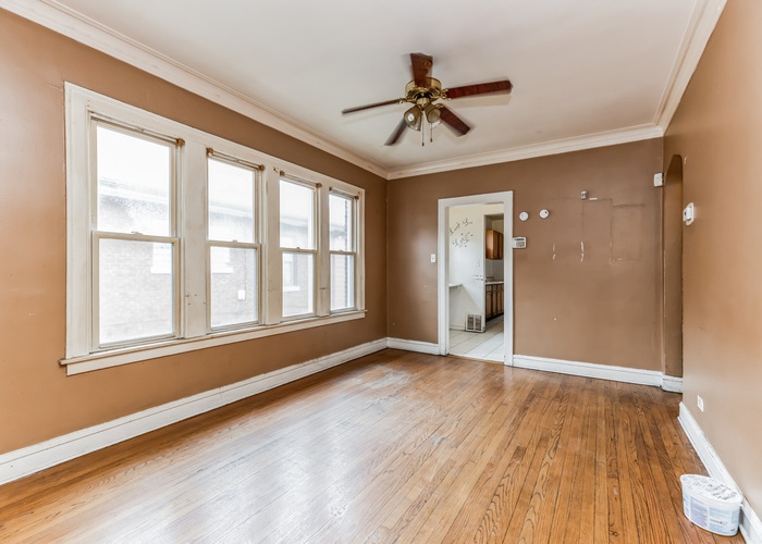 10805 South Normal Avenue Chicago, IL 60628 - Photo 9 of 26 a view of an empty room with a window and wooden floor