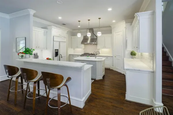 a kitchen with kitchen island granite countertop a sink cabinets and wooden floor