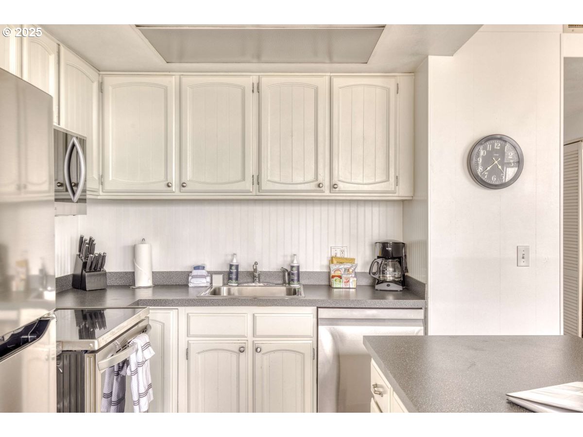 475 South Promenade, Unit 112 Seaside, OR 97138 - Photo 11 of 32 a kitchen with stainless steel appliances granite countertop a sink and cabinets