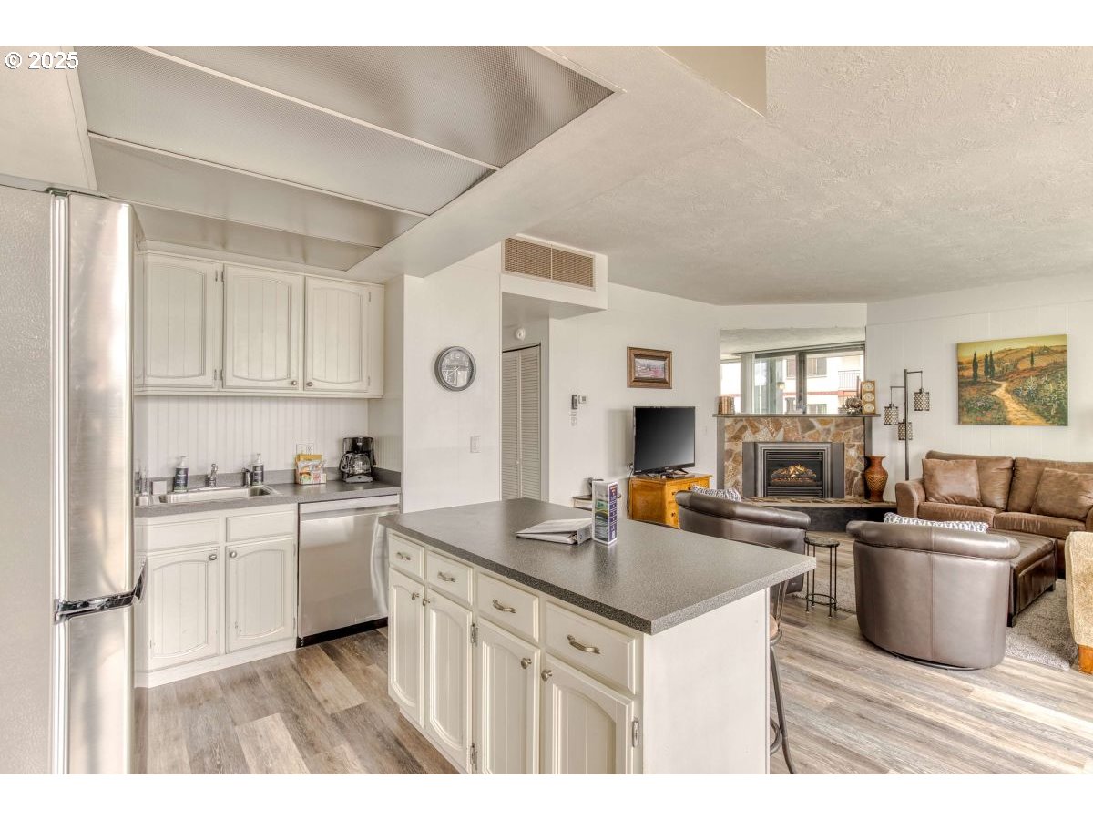 475 South Promenade, Unit 112 Seaside, OR 97138 - Photo 12 of 32 a kitchen with stainless steel appliances granite countertop a sink stove and refrigerator