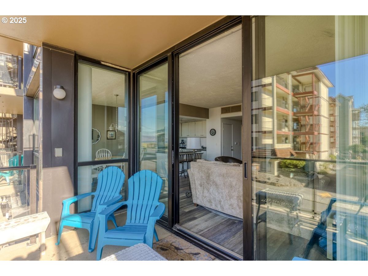 475 South Promenade, Unit 112 Seaside, OR 97138 - Photo 15 of 32 a balcony with furniture and a glass door