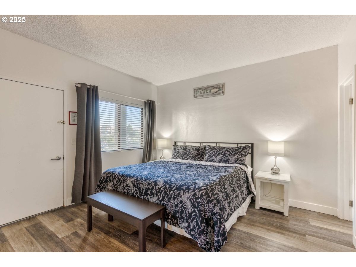 475 South Promenade, Unit 112 Seaside, OR 97138 - Photo 18 of 32 a bedroom with a bed and a table in it