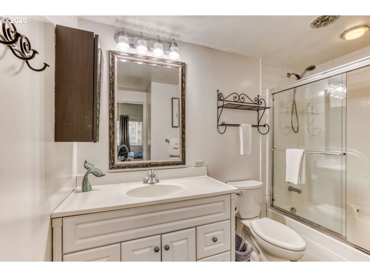 475 South Promenade, Unit 112 Seaside, OR 97138 - Photo 21 of 32 a bathroom with a sink toilet a mirror and shower
