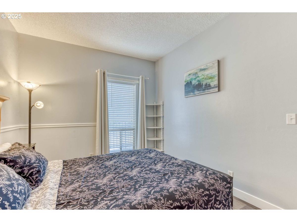 475 South Promenade, Unit 112 Seaside, OR 97138 - Photo 22 of 32 a bedroom with a bed and a bathroom