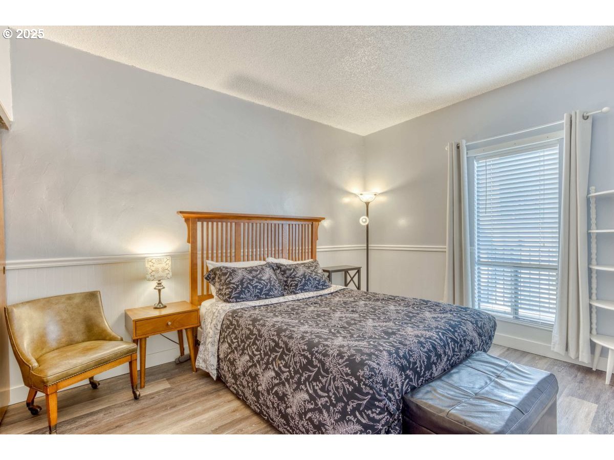 475 South Promenade, Unit 112 Seaside, OR 97138 - Photo 23 of 32 a bedroom with a bed and chair