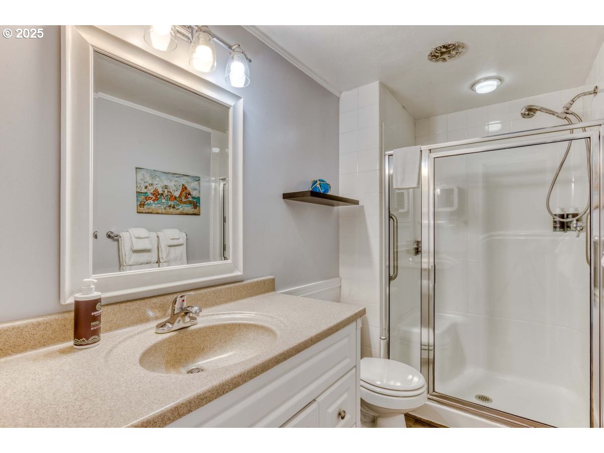 475 South Promenade, Unit 112 Seaside, OR 97138 - Photo 24 of 32 a bathroom with a granite countertop toilet sink and shower