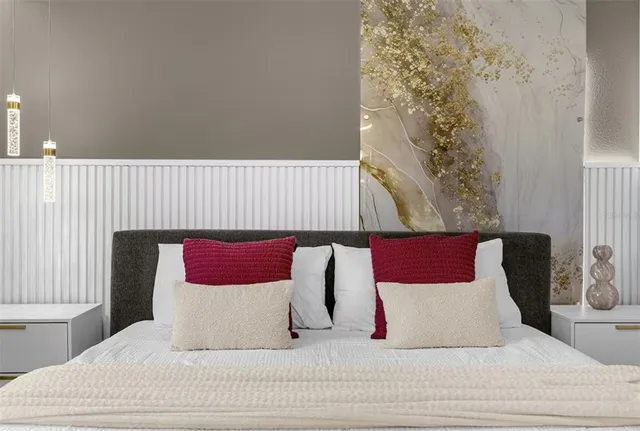 a bedroom with a bed and painting on the wall