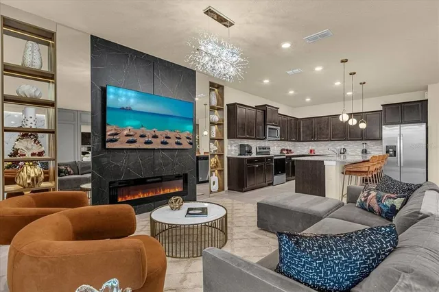 a living room with furniture kitchen and a chandelier