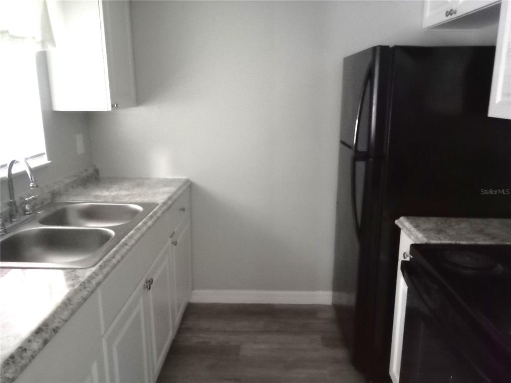 1217 Kennedy Road, Unit 56 Daytona Beach, FL 32117 - Photo 3 of 6 a kitchen with a sink and a refrigerator