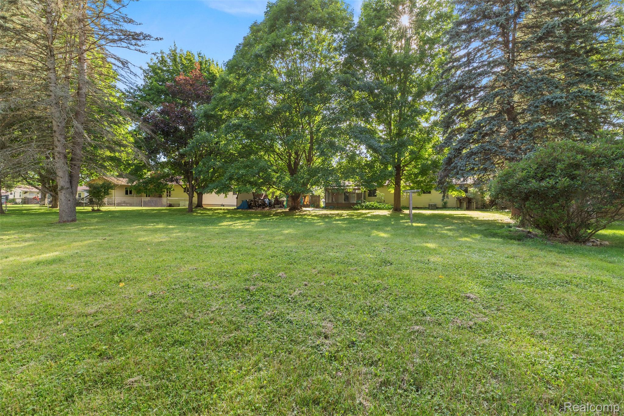 309 Windy Bluff Street Flushing, MI 48433 - Photo 30 of 32 Expansive green lawn surrounded by mature trees, providing natural shade