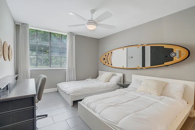 a bedroom with 2 bed and a window