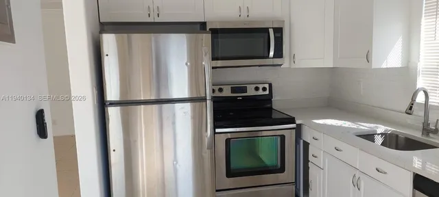 a kitchen with stainless steel appliances granite countertop a stove a microwave and a refrigerator