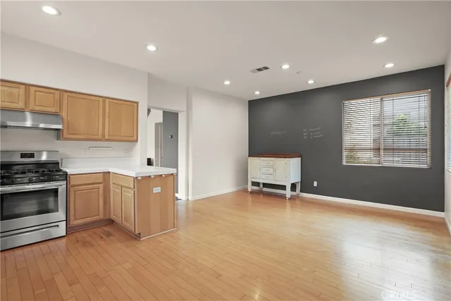 a kitchen with granite countertop a stove a sink and a refrigerator