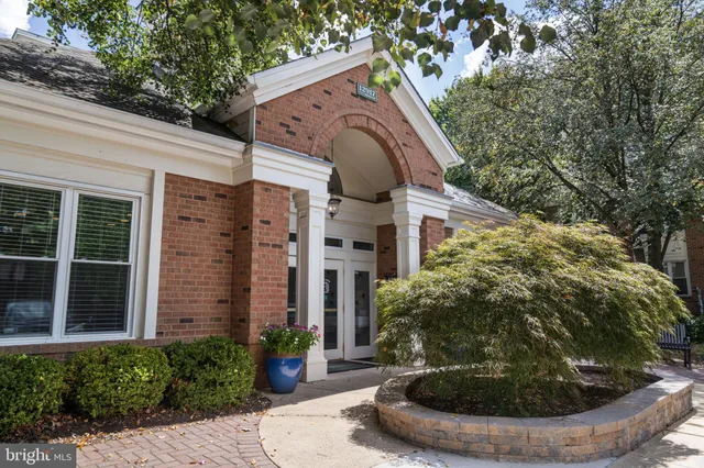 an aerial view of a house with a yard and trees all around