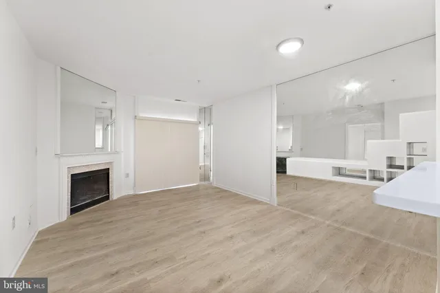 a view of an empty room with a fireplace and a window