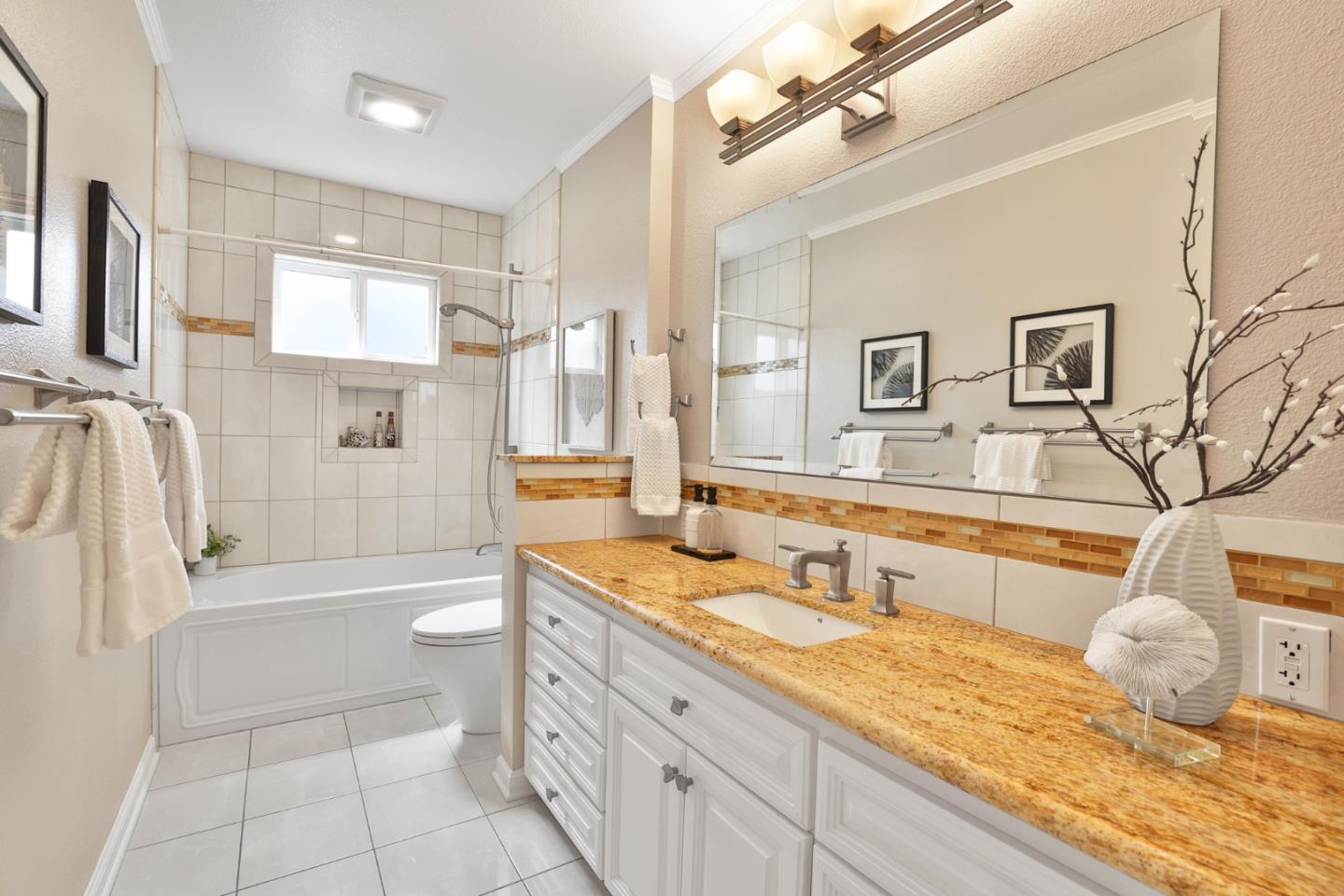 148 Jacinto Way Sunnyvale, CA 94086 - Photo 16 of 27 a bathroom with a granite countertop sink a mirror a bathtub and shower