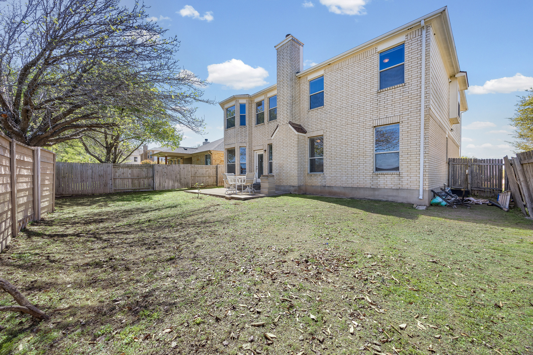 3502 Shiraz Loop Round Rock, TX 78665 - Photo 20 of 23 Rear view of property with brick siding, a chimney, a fenced backyard, and a patio area
