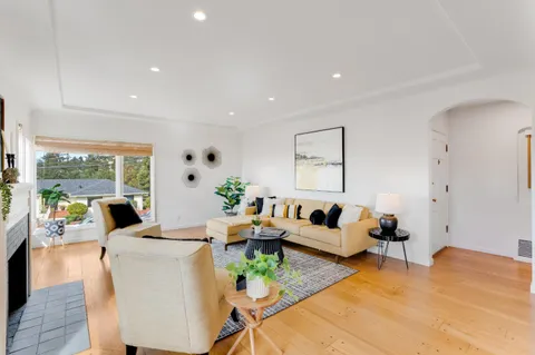 a living room with furniture floor to ceiling window and wooden floor
