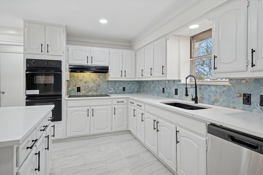 62 Legend Road Benbrook, TX 76132 - Photo 9 of 27 The gourmet island kitchen features designer backsplash, double ovens, electric cooktop, abundance of cabinets and counters - and opens to the breakfast room.