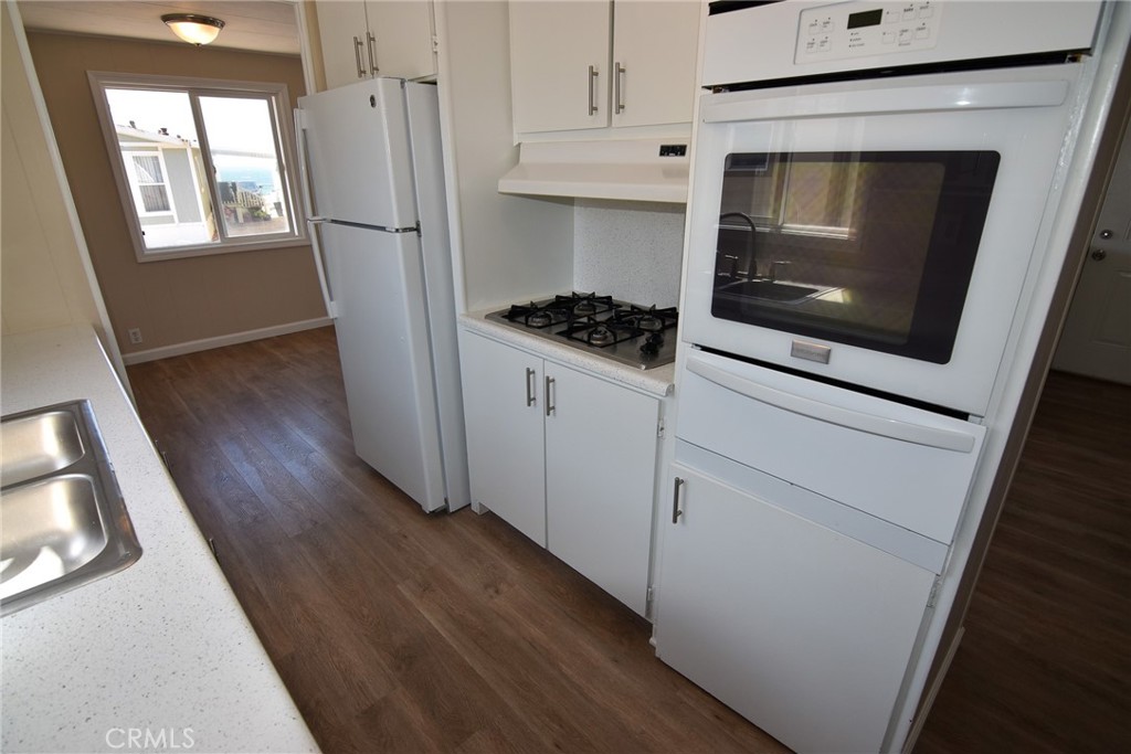 340 3rd Avenue, Unit 43 Pacifica, CA 94044 - Photo 10 of 19 a kitchen with a white stove and wooden floor