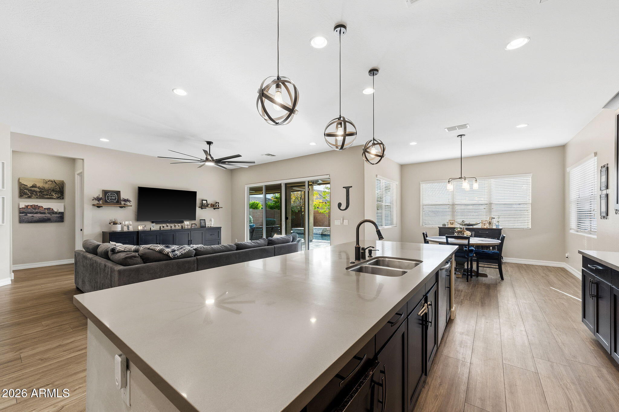 3921 East Chestnut Lane Gilbert, AZ 85298 - Photo 7 of 18 a large kitchen with kitchen island a counter space a sink and living room view