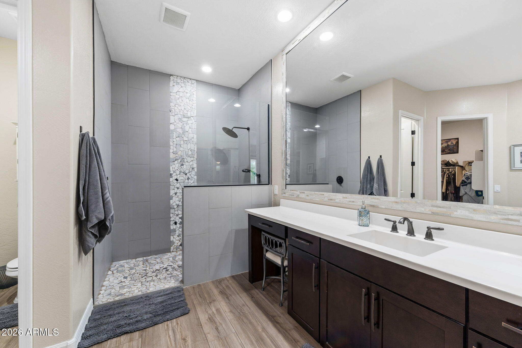 3921 East Chestnut Lane Gilbert, AZ 85298 - Photo 9 of 18 a bathroom with a double vanity sink a mirror and a shower