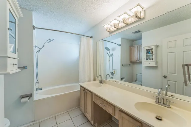 a bathroom with a tub a sink shower and a mirror