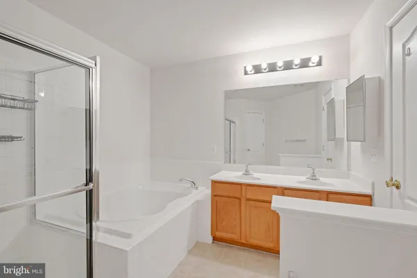 a bathroom with a granite countertop sink mirror and a bathtub