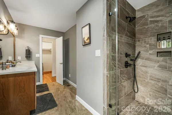 a bathroom with a granite countertop shower a sink and a mirror