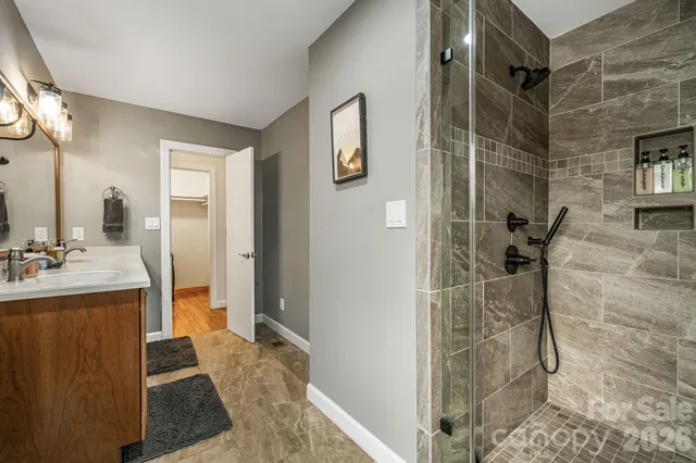 a bathroom with a granite countertop shower a sink and a mirror