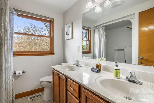 a bathroom with a granite countertop sink toilet and a mirror