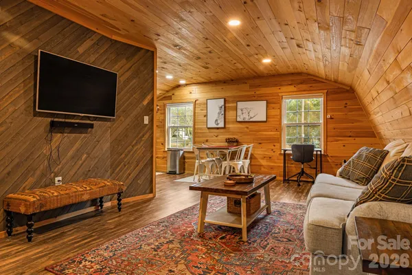 a living room with furniture a flat screen tv and paintings on the wall