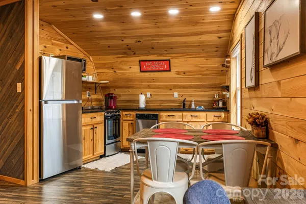 a storage room with stainless steel appliances kitchen island granite countertop a refrigerator and a stove