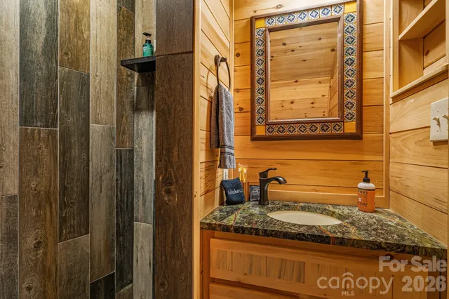 a bathroom with a granite countertop sink and a mirror