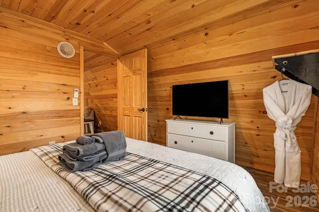 a bedroom with a bed and flat screen tv