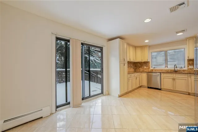 a large white kitchen with a sink and refrigerator